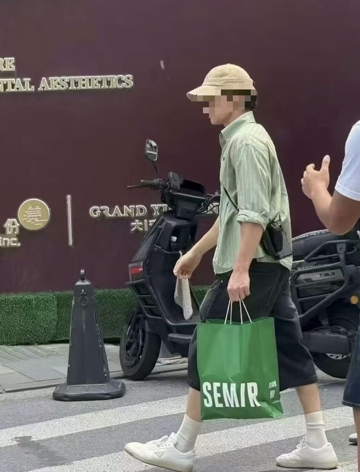 Tom Holland walking in Shanghai carrying a green Semir shopping bag